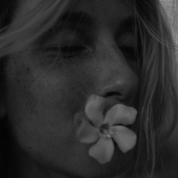 Portrait femme tenant une fleur dans sa bouche